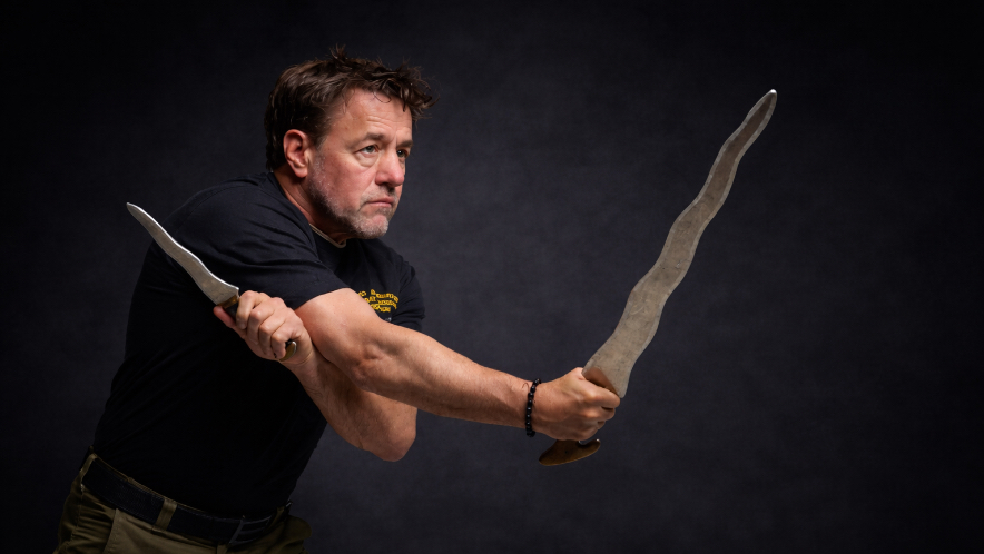 Guro Alan Baker training with two kali sticks - Filipino Kali is a weapon-based martial art that teaches stick, blade, and empty-hand fighting through angles, footwork, timing, and flow, with a focus on practical skills that translate across tools and ranges.