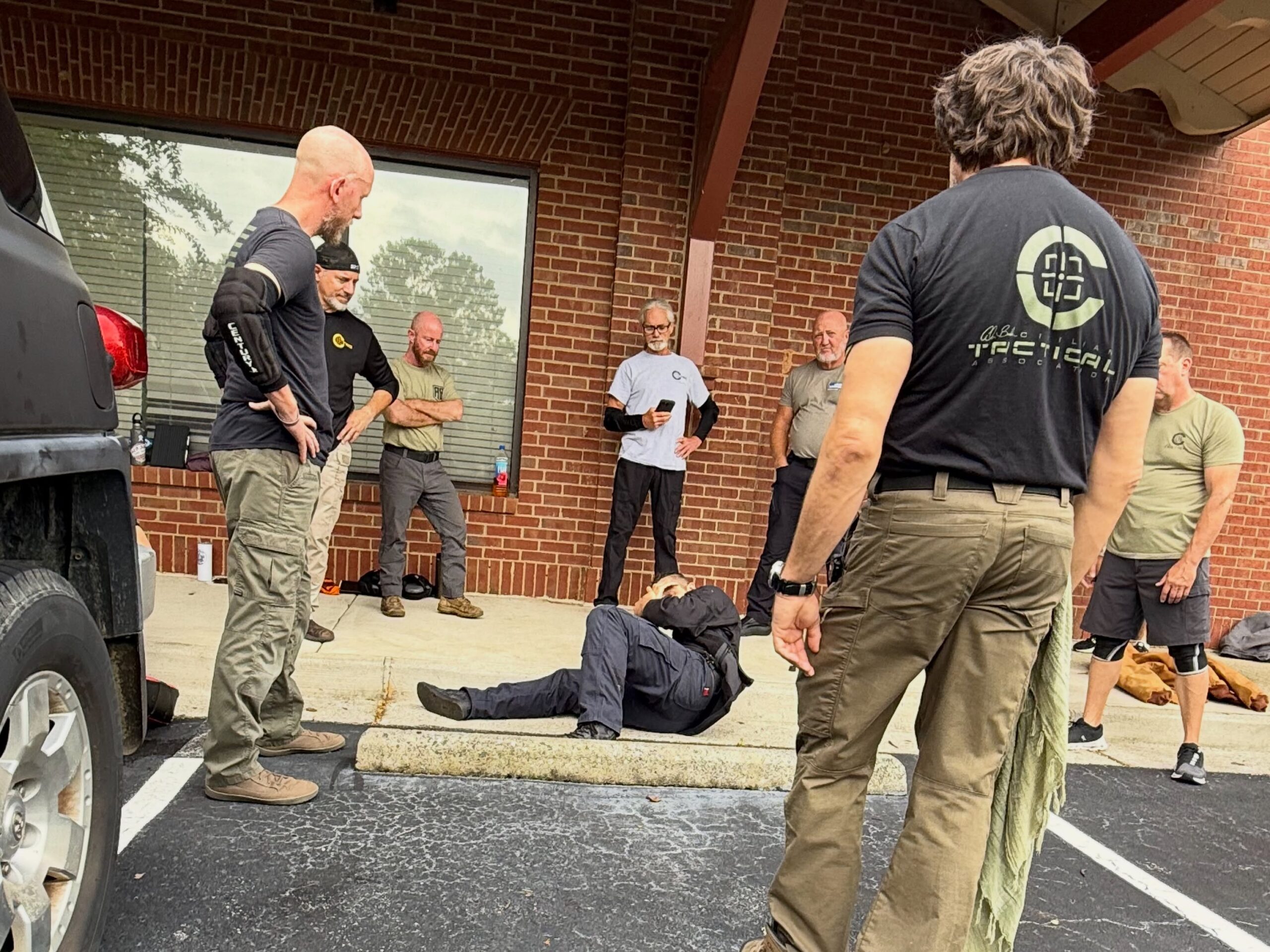 C-TAC participants training around a vehicle, wall, and curb in a parking lot