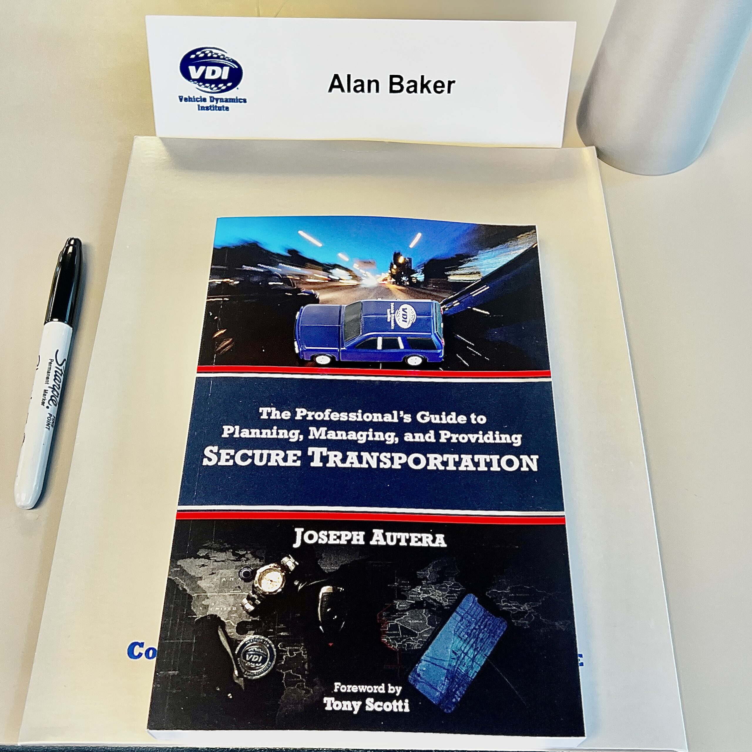 Joe Autera’s secure transportation book at Alan Baker’s Vehicle Dynamics Institute classroom seat.