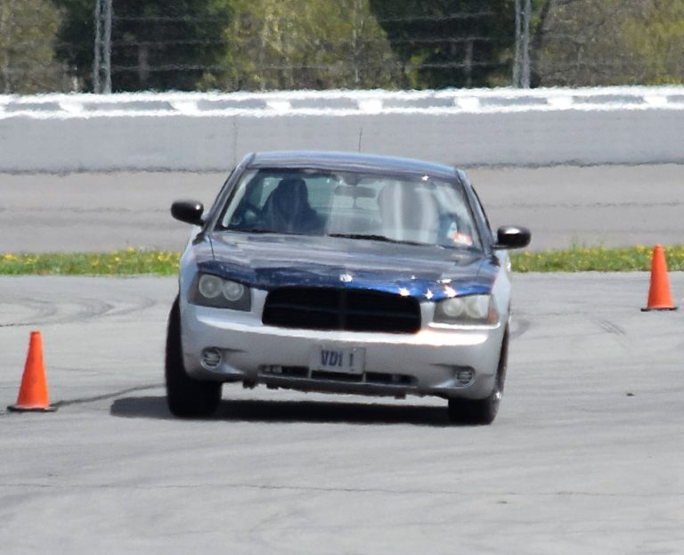 Protective driving student guiding a sedan through a cone exercise at Pocono Raceway.