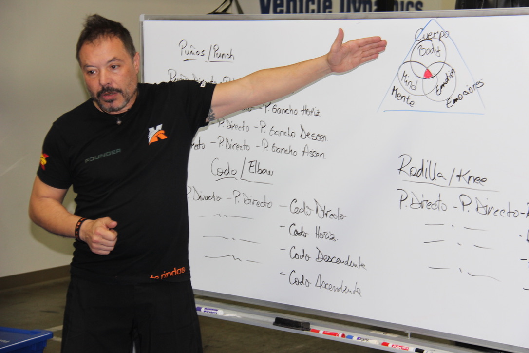 Keysi Fighting Method founder Justo Dieguez teaching concepts from a whiteboard