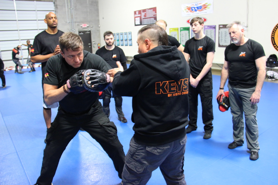 Keysi Fighting Method students training close-range defensive movement under instructor supervision